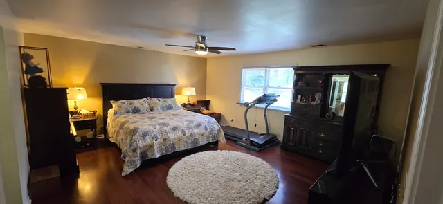 a bedroom with a bed and wooden floor
