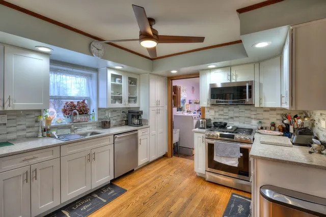 a kitchen with stainless steel appliances granite countertop a sink stove and refrigerator