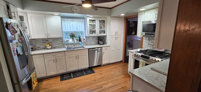 a kitchen with white cabinets and appliances