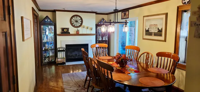 a dining room with furniture a fireplace and a chandelier