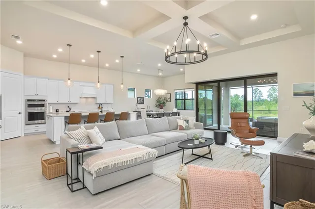 a living room with furniture kitchen and a chandelier