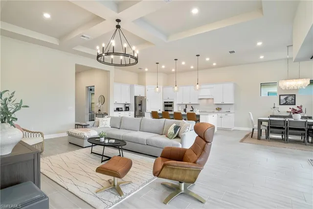 a living room with furniture kitchen view and a chandelier