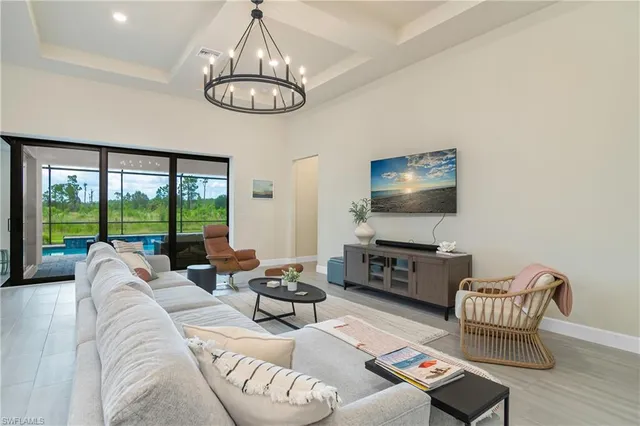 a living room with furniture flat screen tv and a large window