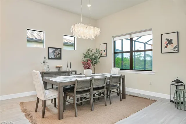 a view of a dining room with furniture a chandelier and wooden floor