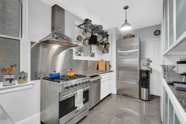 a kitchen with stainless steel appliances granite countertop a sink and a refrigerator