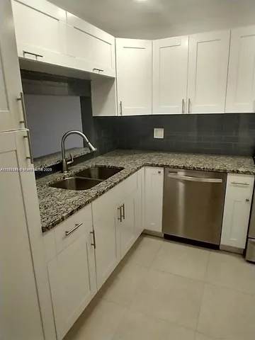 a kitchen with granite countertop a sink and a stove