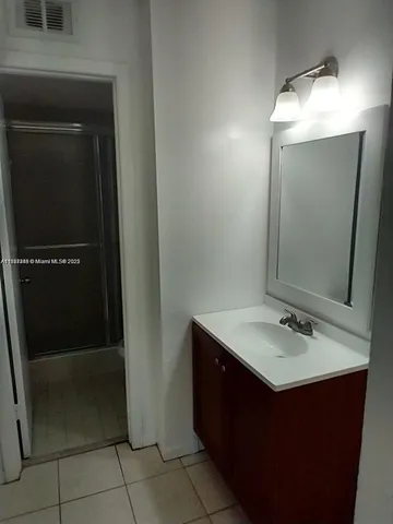 a bathroom with a sink vanity and a mirror
