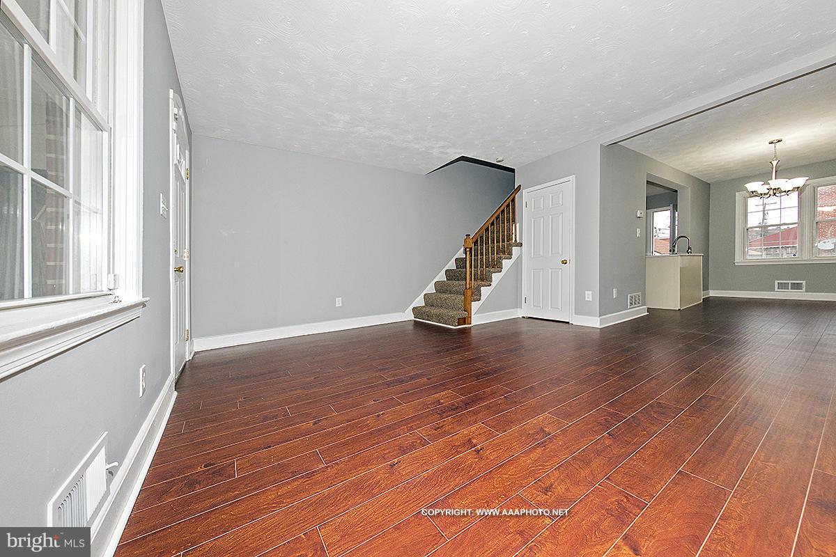 417 Grovethorn Road Middle River, MD 21220 - Photo 2 of 12 a view of an empty room with wooden floor and stairs