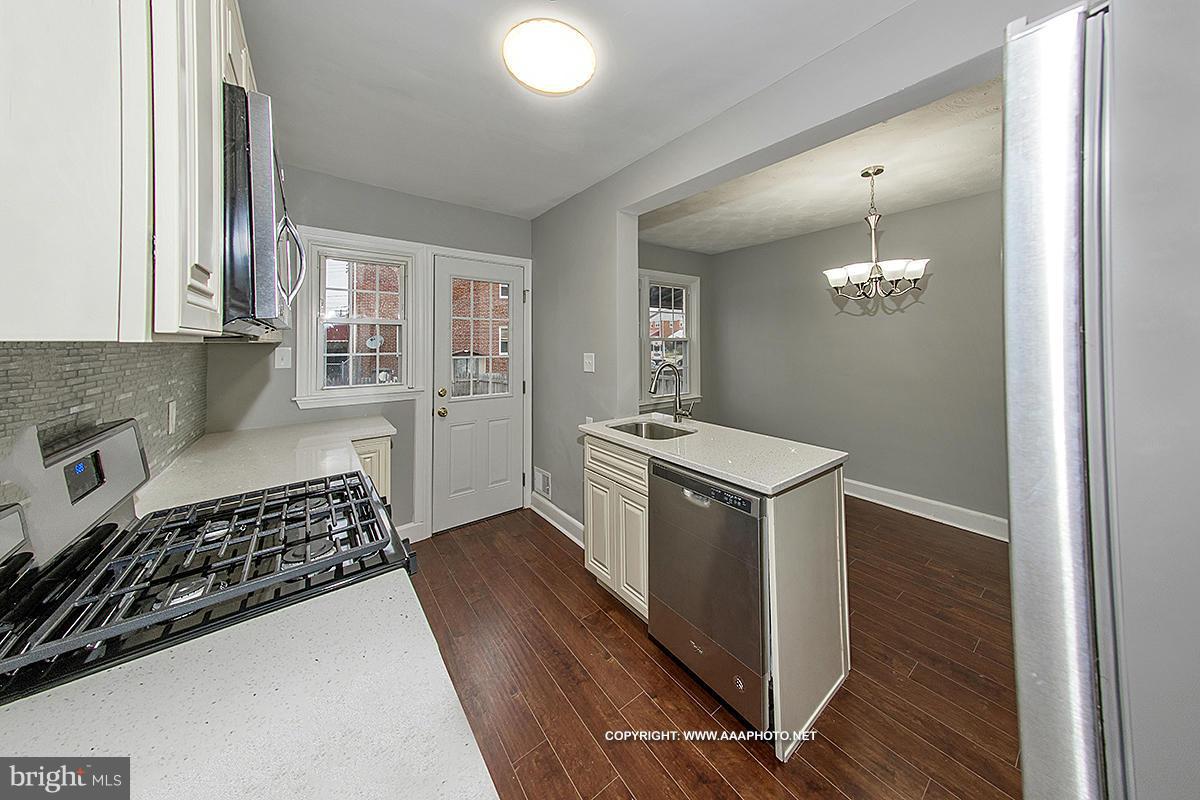 417 Grovethorn Road Middle River, MD 21220 - Photo 4 of 12 a kitchen with a stove and wooden floor