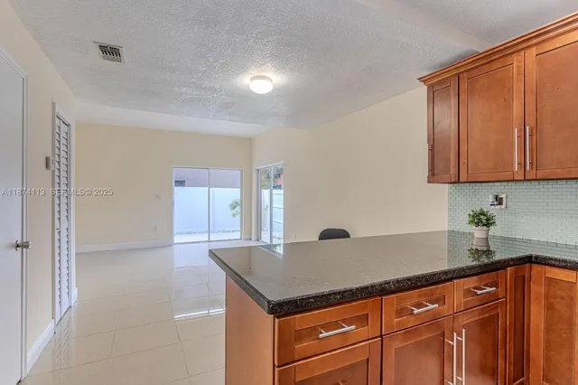 a kitchen with granite countertop a sink and a cabinets