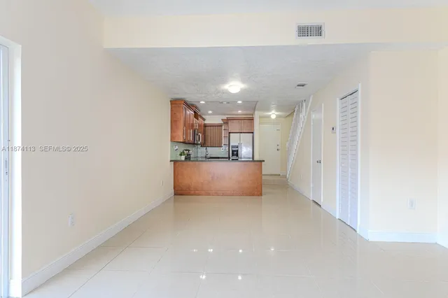 a view of kitchen with refrigerator and window