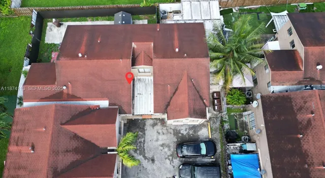 an aerial view of residential houses with outdoor space and parking