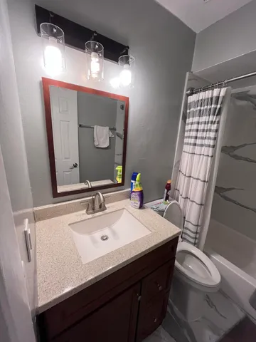 a bathroom with a sink vanity mirror and toilet