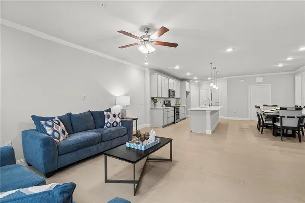 a living room with furniture and kitchen view