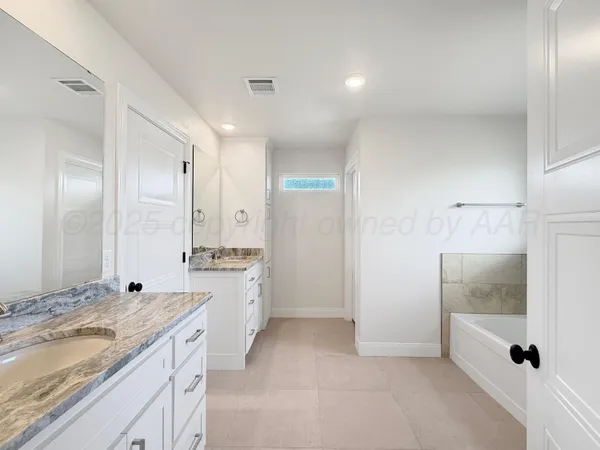 a spacious bathroom with a granite countertop sink a mirror and shower