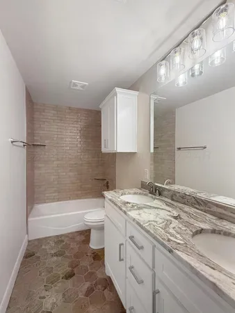 a bathroom with a sink a toilet and bathtub