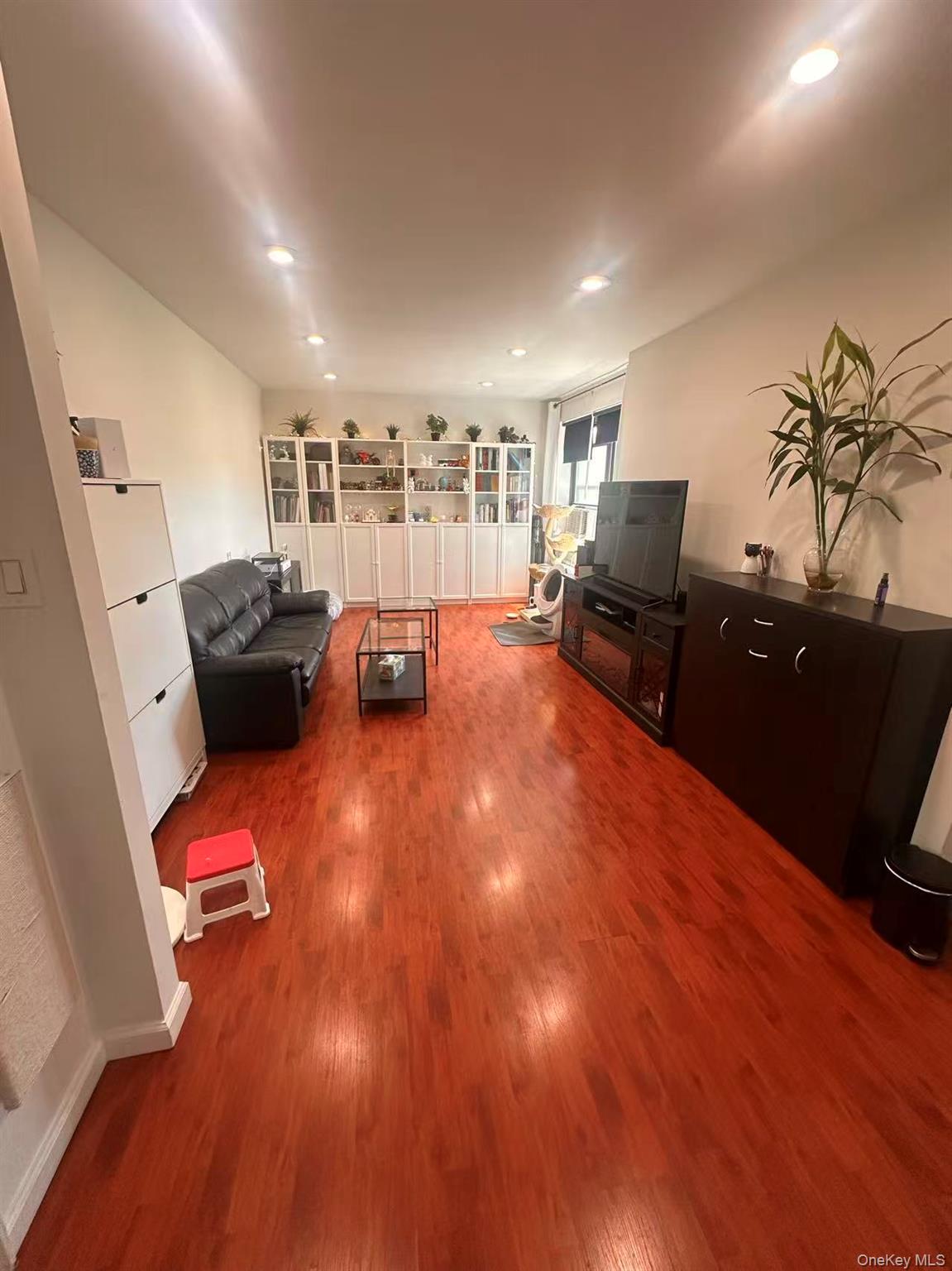 139-15 28th Road, Unit 6G Queens, NY 11354 - Photo 1 of 20 a living room with furniture and a flat screen tv