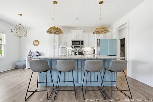 a view of a kitchen with stainless steel appliances wooden floor and a window