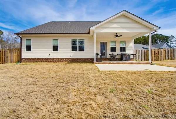a view of a house with backyard and sitting area