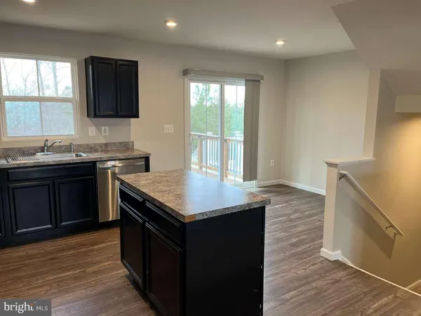 a kitchen with granite countertop a refrigerator and a stove top oven