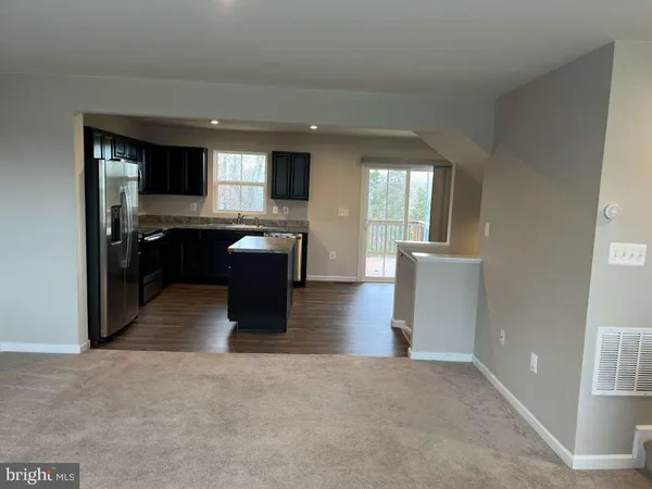 a kitchen with stainless steel appliances kitchen island granite countertop a stove a sink and a refrigerator