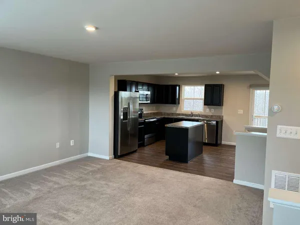 a view of a kitchen island a sink dishwasher refrigerator stove and cabinets