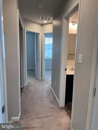 a view of an empty room with a window and bathroom