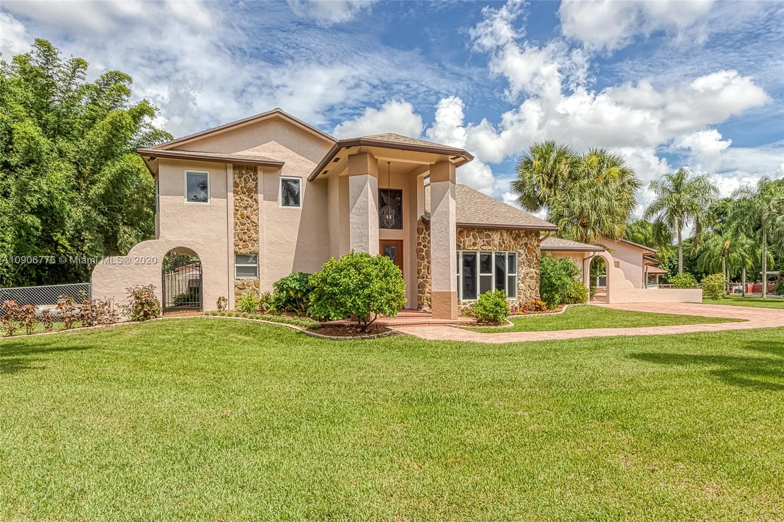 4860 Southwest 193rd Lane Southwest Ranches, FL 33332 - Photo 2 of 80 a front view of a house with a garden and porch