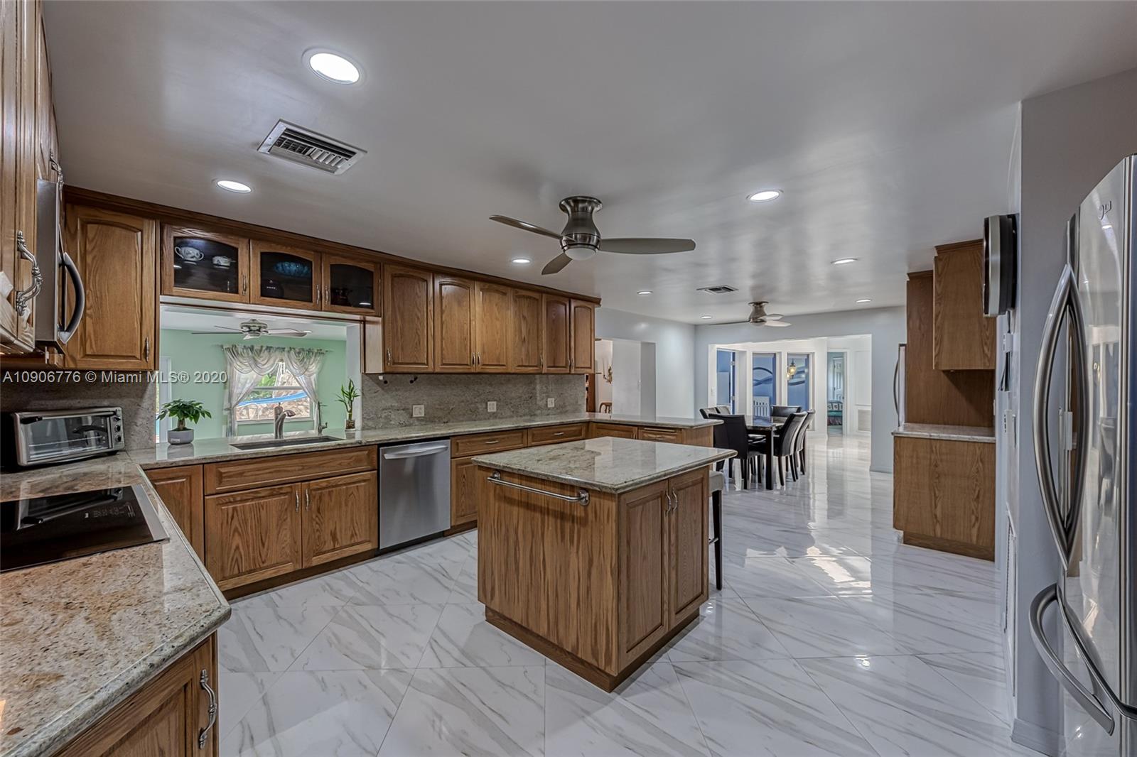 4860 Southwest 193rd Lane Southwest Ranches, FL 33332 - Photo 23 of 80 a kitchen with stainless steel appliances granite countertop sink stove top oven and refrigerator
