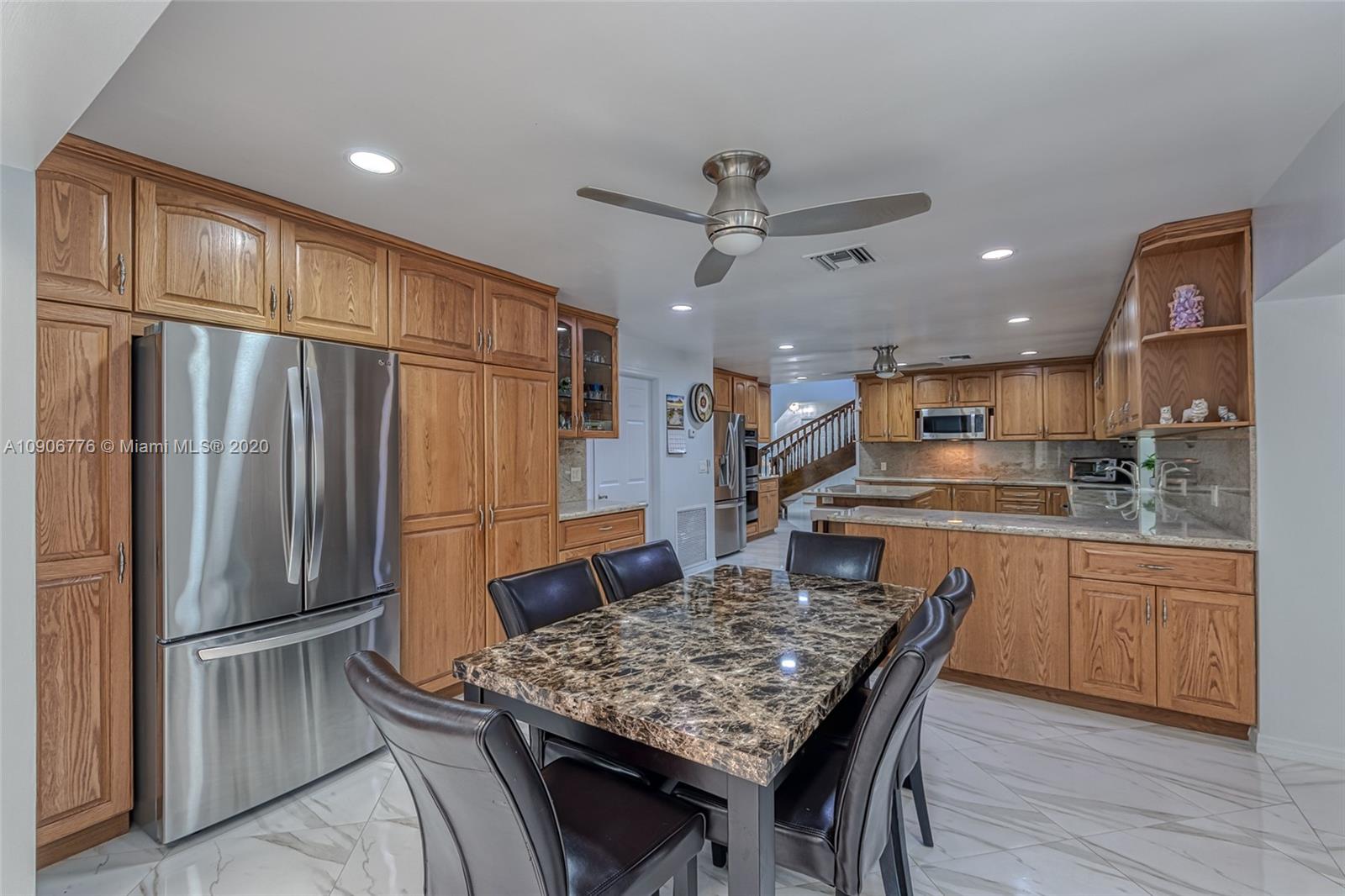 4860 Southwest 193rd Lane Southwest Ranches, FL 33332 - Photo 32 of 80 a kitchen with stainless steel appliances granite countertop a refrigerator and a stove top oven