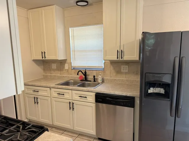 a kitchen with stainless steel appliances a sink stove and refrigerator