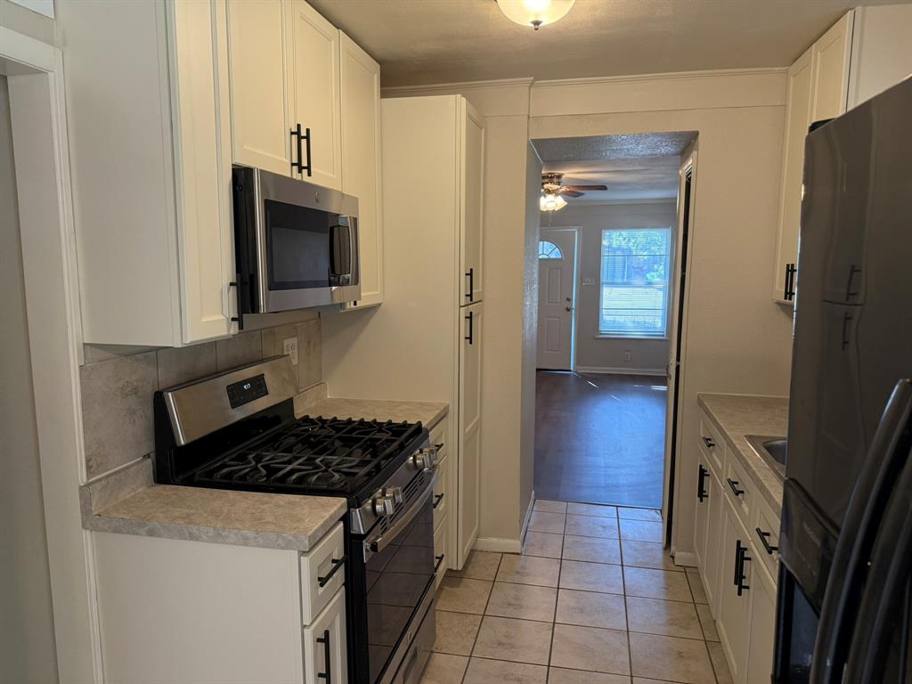 625 South Andrews Avenue Sherman, TX 75090 - Photo 14 of 17 a kitchen with granite countertop a stove and a refrigerator