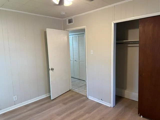 an empty room with wooden floor and closet