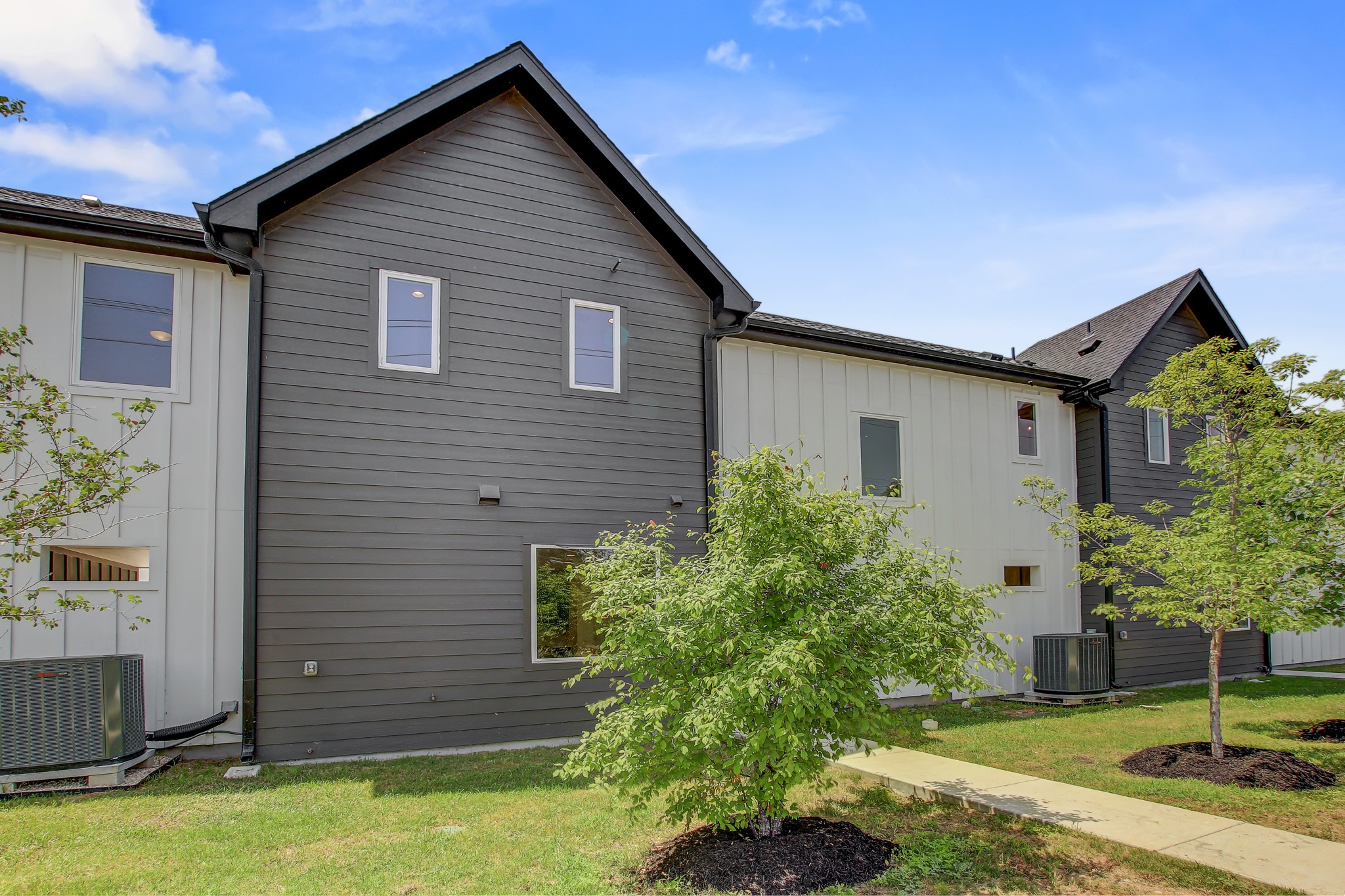4127 East 12th Street, Unit 4 Austin, TX 78721 - Photo 31 of 32 View of property exterior with central AC unit and a lawn