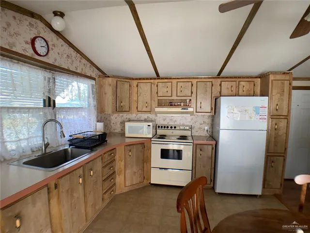 a kitchen with a refrigerator sink and cabinets