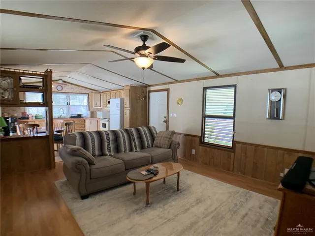 a living room with furniture a ceiling fan and a window