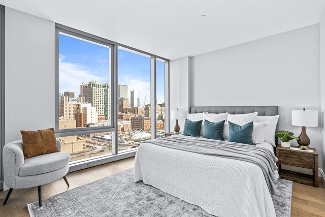 a spacious bedroom with a bed and a couch next to a window