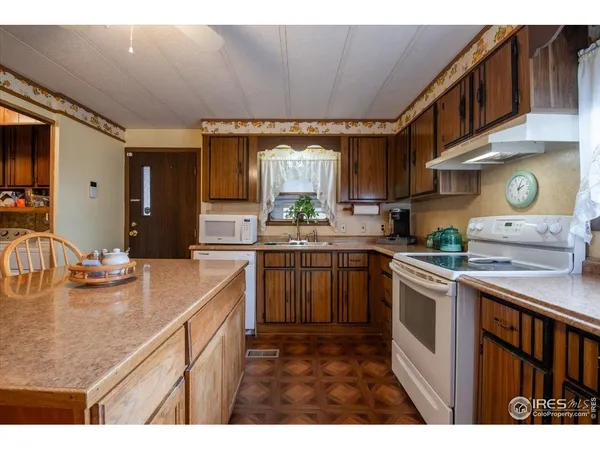 a kitchen with stainless steel appliances granite countertop a sink dishwasher stove and cabinets with wooden floor
