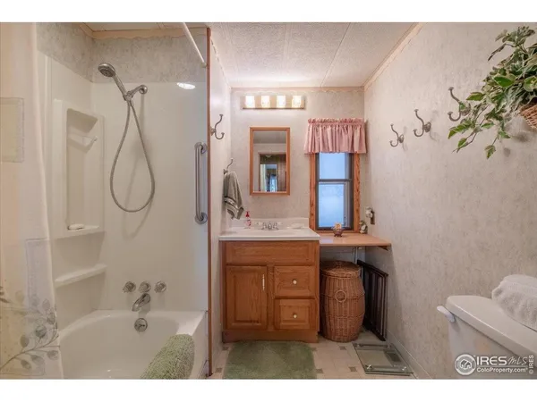 a bathroom with a granite countertop sink a toilet and shower