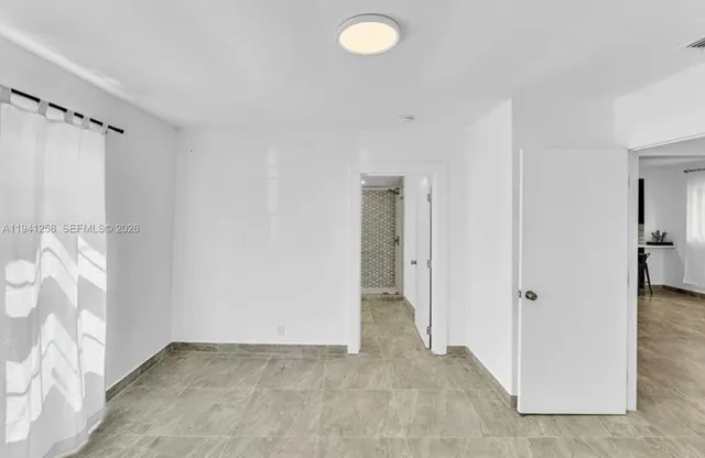 an empty room with closet area and windows