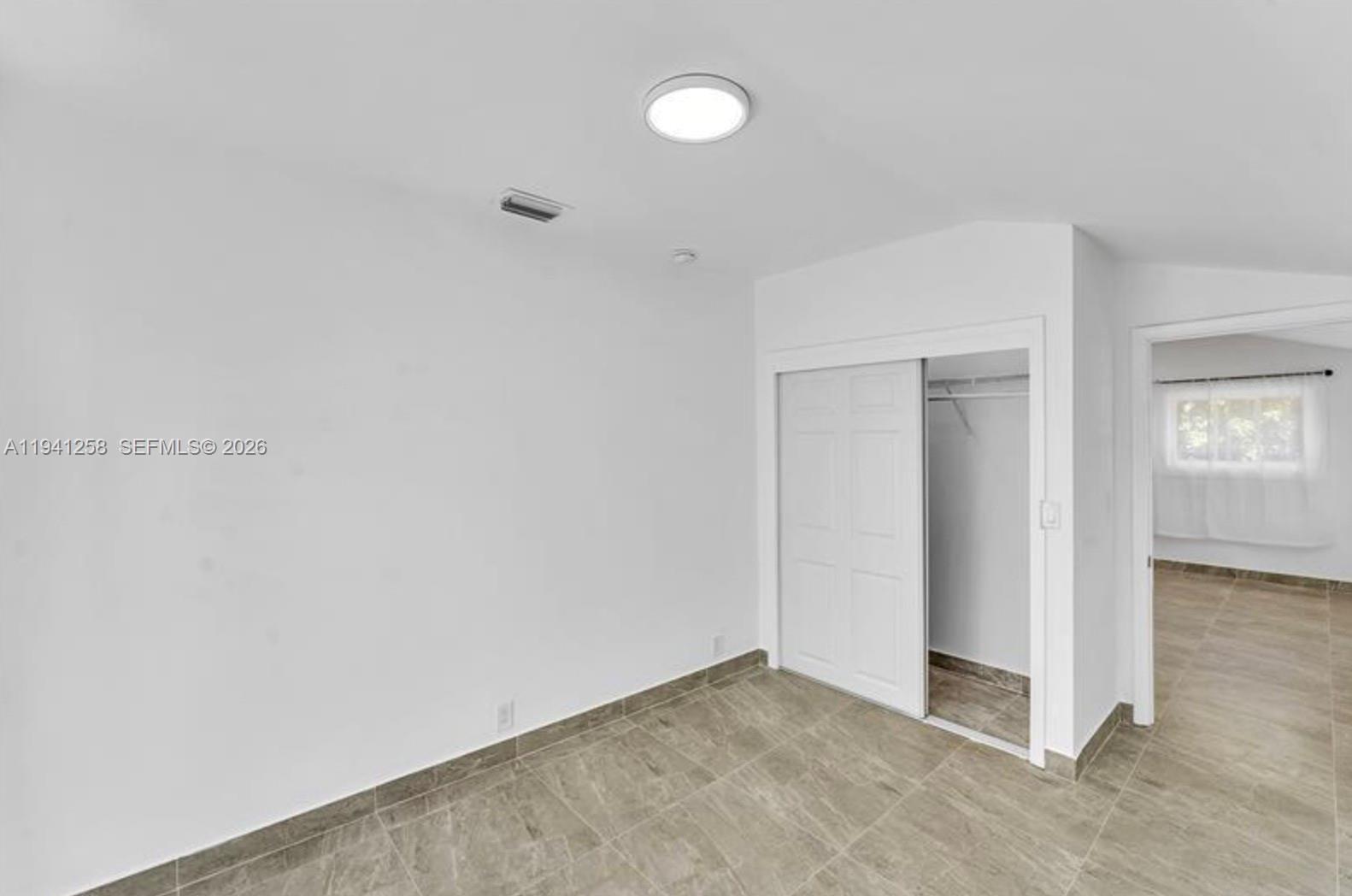 211 Southeast 9th Street Hallandale Beach, FL 33009 - Photo 14 of 16 an empty room with closet area and windows