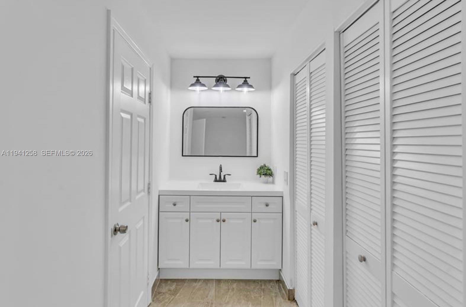 211 Southeast 9th Street Hallandale Beach, FL 33009 - Photo 7 of 16 a bathroom with a sink and a mirror