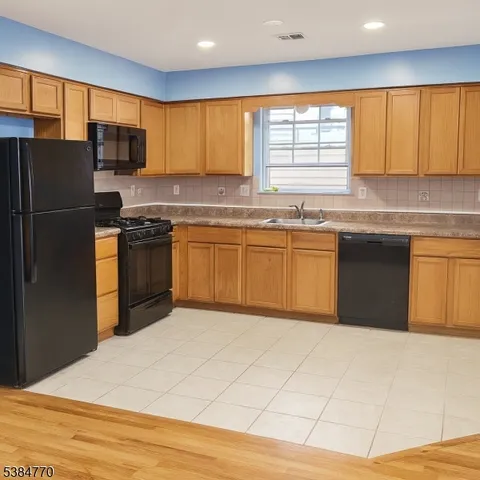 a kitchen with stainless steel appliances granite countertop a stove a sink dishwasher a refrigerator and a microwave oven