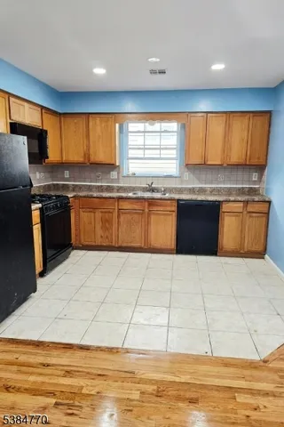 a large kitchen with granite countertop a large counter top space appliances and cabinets