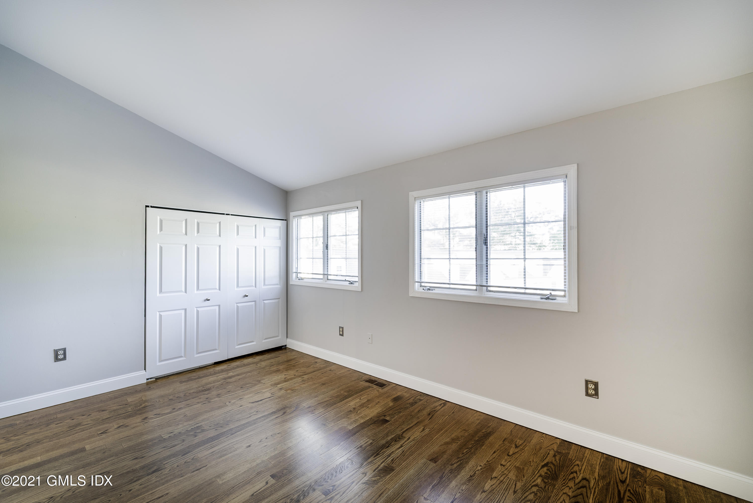 150 Prospect Street, Unit 23 Greenwich, CT 06830 - Photo 12 of 20 an empty room with wooden floor and windows