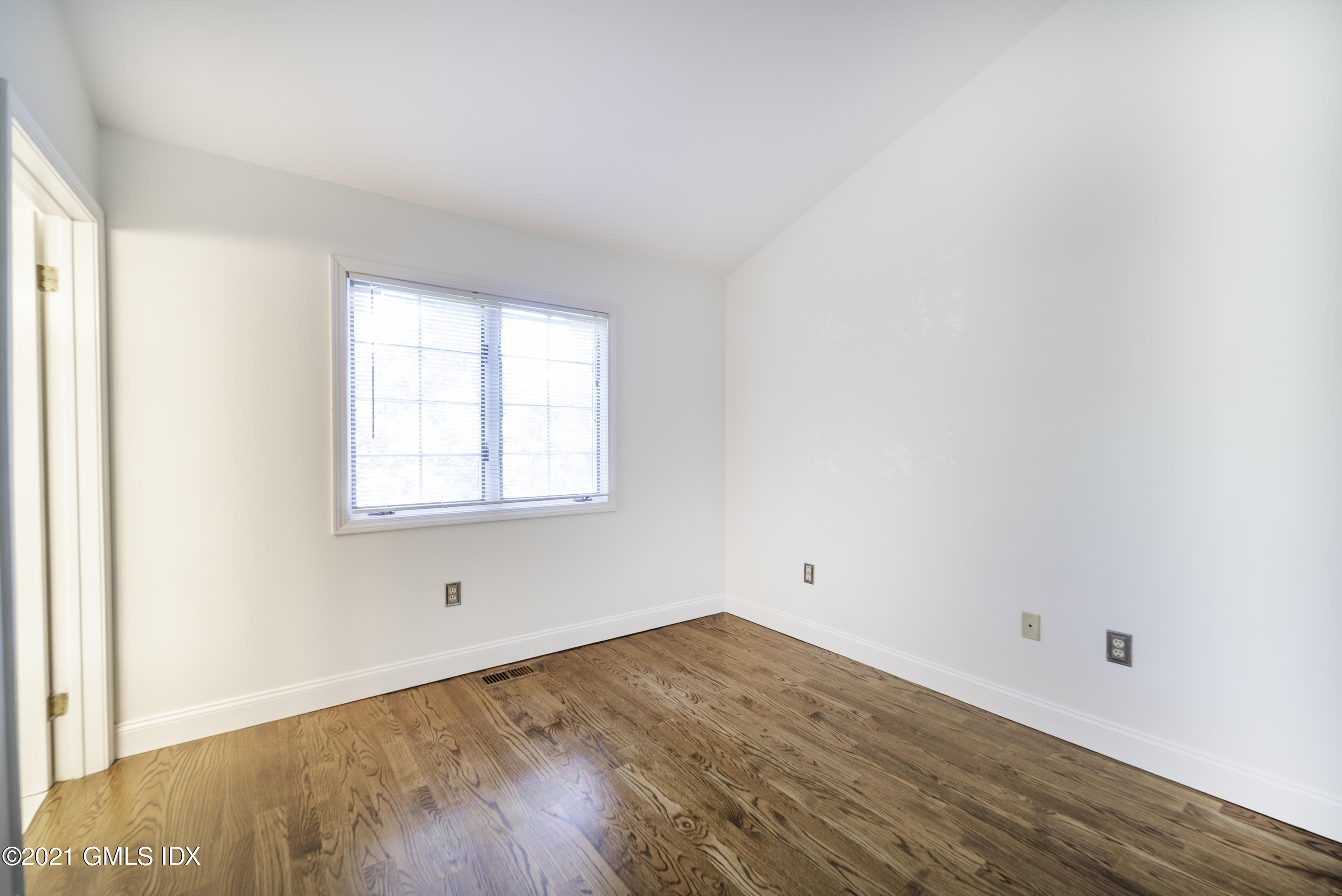 150 Prospect Street, Unit 23 Greenwich, CT 06830 - Photo 15 of 20 an empty room with wooden floor and windows