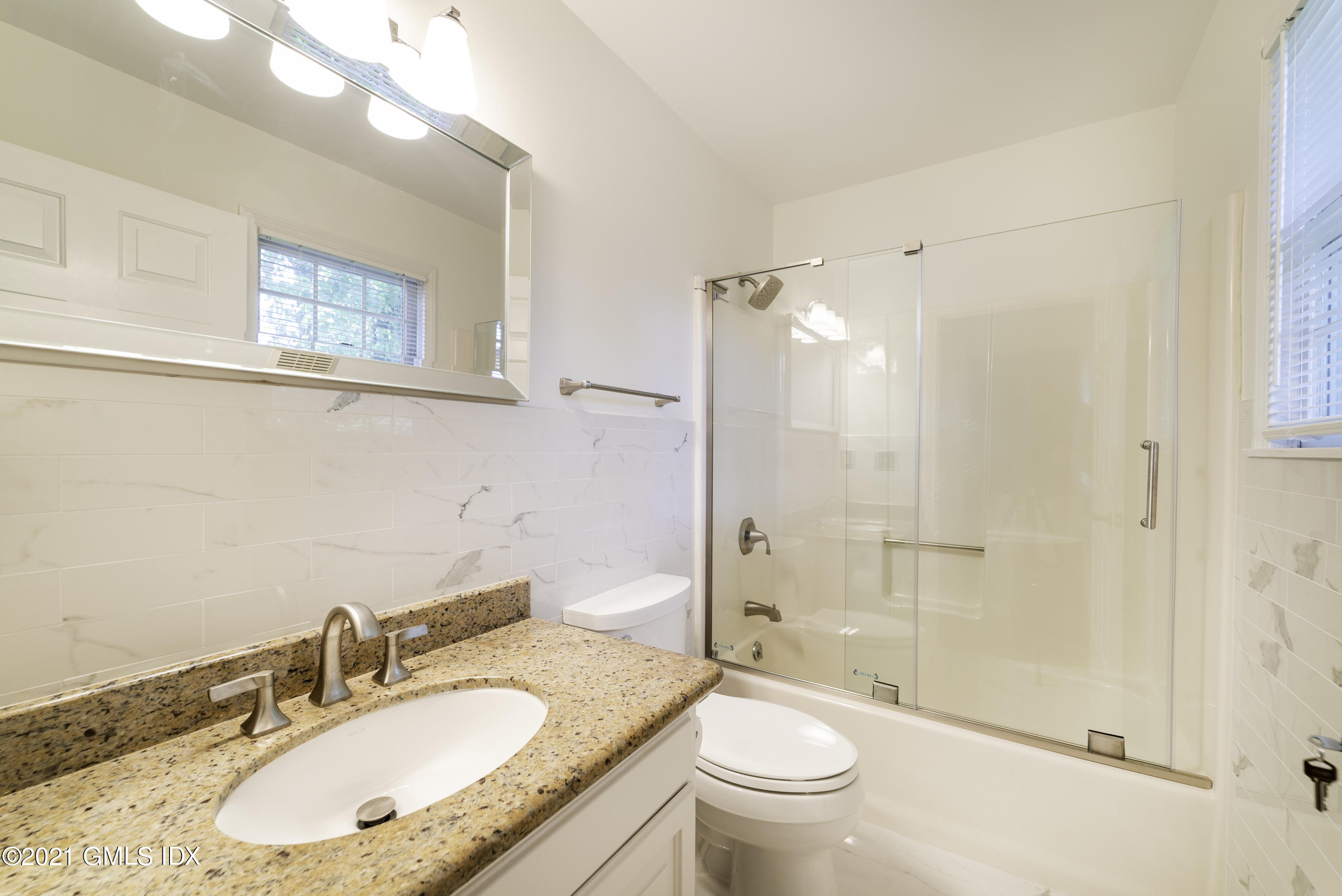 150 Prospect Street, Unit 23 Greenwich, CT 06830 - Photo 18 of 20 a bathroom with a granite countertop sink toilet and shower