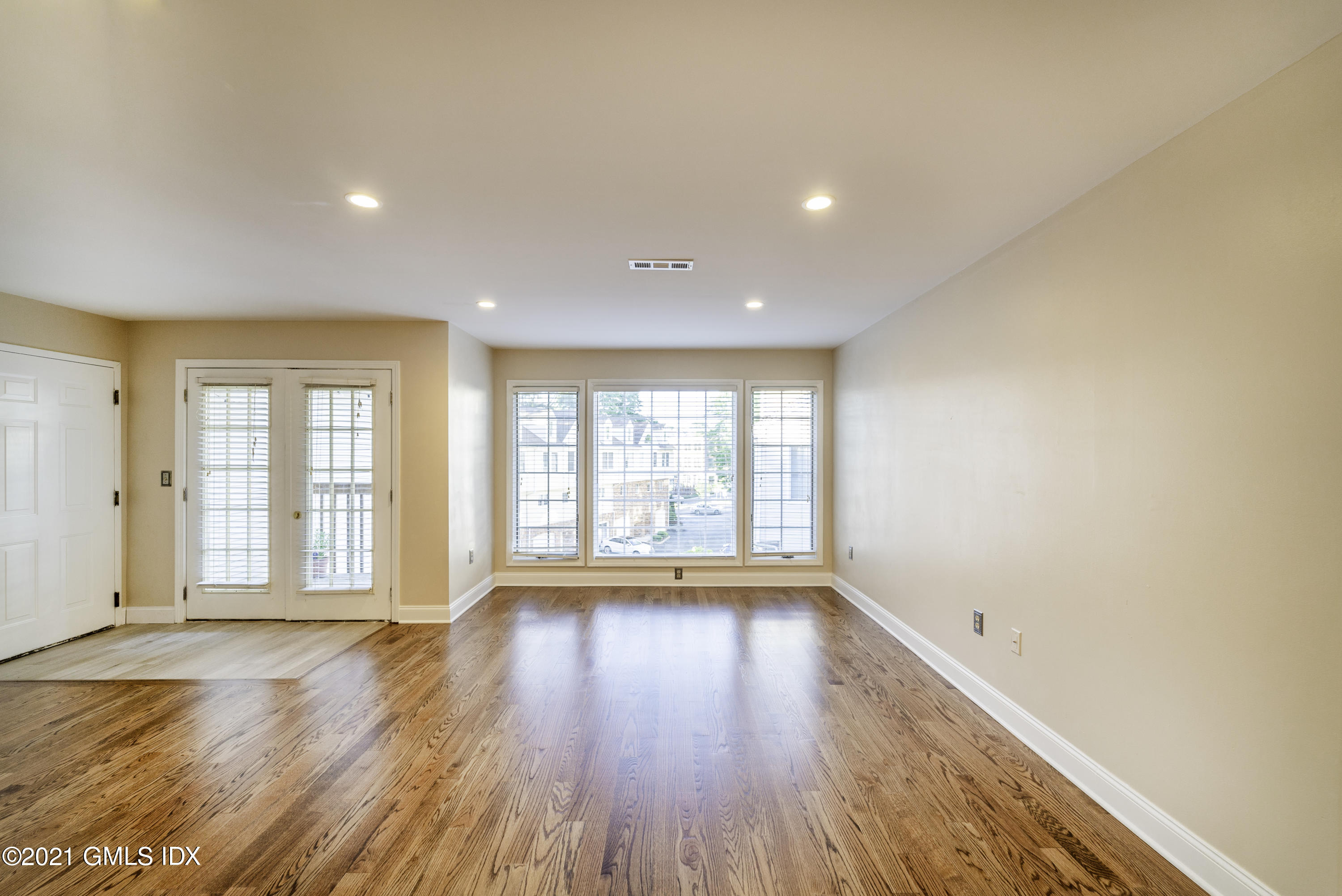 150 Prospect Street, Unit 23 Greenwich, CT 06830 - Photo 3 of 20 a view of an empty room with wooden floor and a window