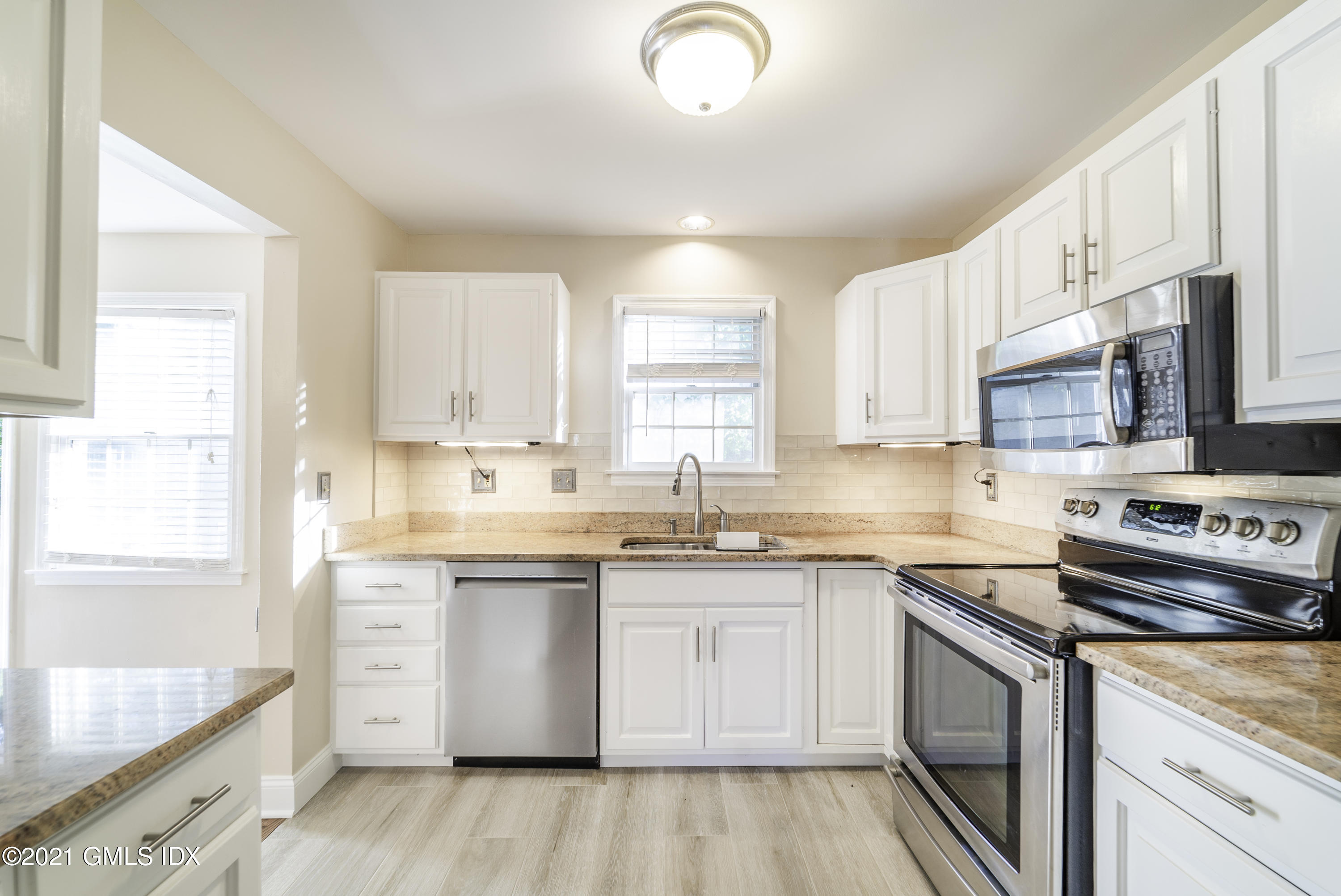 150 Prospect Street, Unit 23 Greenwich, CT 06830 - Photo 9 of 20 a kitchen with stainless steel appliances granite countertop a sink and cabinets