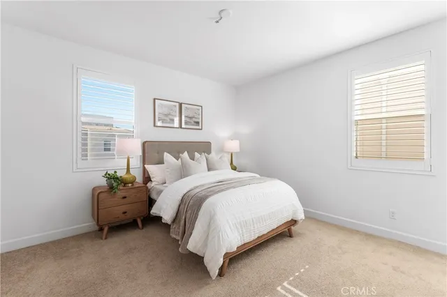 a bed sitting in a bedroom next to a window